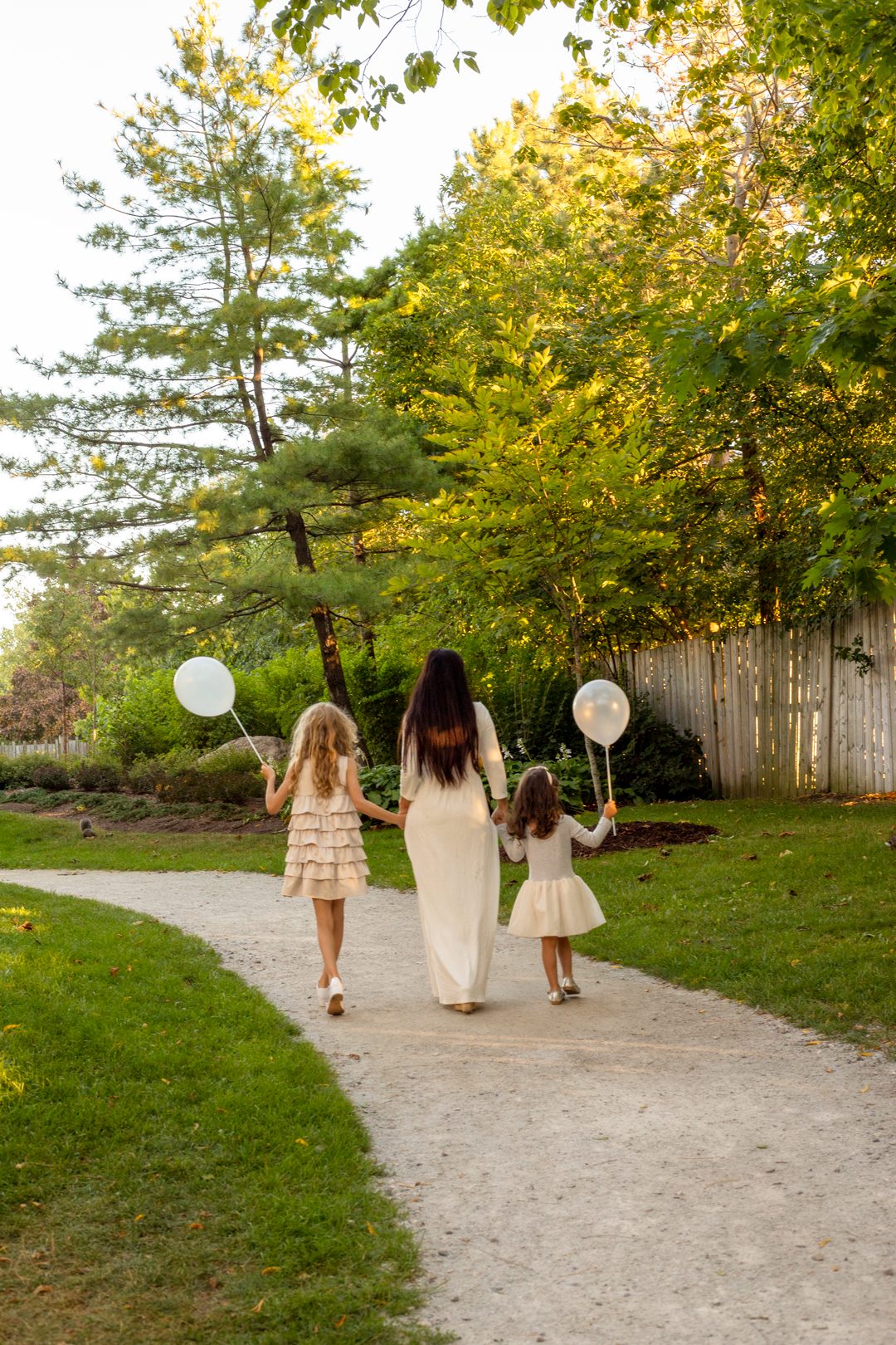 Mother and daughters walking with balloons